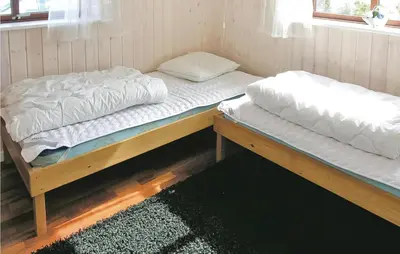 two twin beds sitting in a room with a rug at Casa Blanca in Thisted