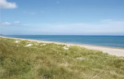 an empty beach with the ocean in the background at Casa Blanca in Thisted