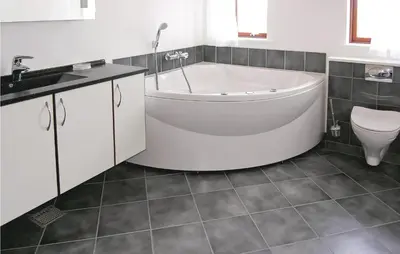 a bathroom with a tub and a toilet and a sink at Casa Blanca in Thisted