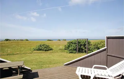 a deck with two white chairs and a bench on it at Stunning Home In Vestervig With Sauna in Vestervig