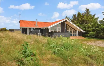 a house with an orange roof on top of a field at Lovely Home In Thisted With Wifi in Thisted