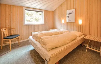 a bedroom with a bed and a chair and a window at Lovely Home In Thisted With Wifi in Thisted