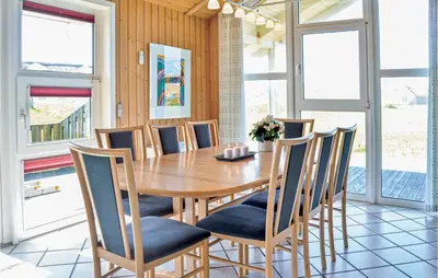 a dining room with a wooden table and chairs at Stunning Home In Thisted With Sauna in Thisted