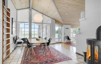 a dining room with a table and chairs and a fireplace at Beautiful Home In Vestervig With Sauna in Vestervig