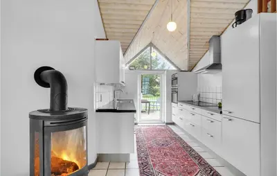 a kitchen with a fireplace in the middle at Beautiful Home In Vestervig With Sauna in Vestervig
