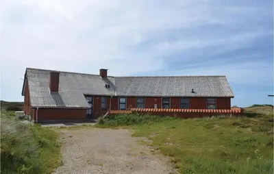 a red house on top of a grassy hill at Awesome Home In Thisted With Sauna in Thisted