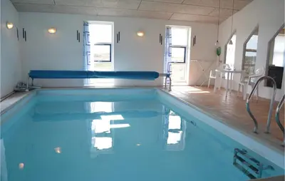 a swimming pool with blue water in a room at Awesome Home In Thisted With Sauna in Thisted