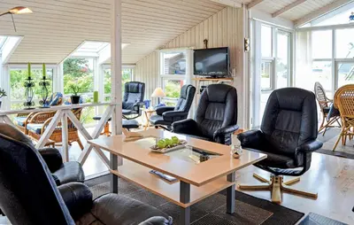 a room with chairs and a table and a tv at Three-Bedroom Holiday Home In Thisted in Thisted