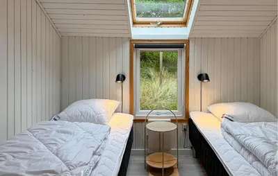 two beds in a small room with a window at Three-Bedroom Holiday Home In Thisted in Thisted
