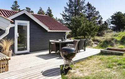 a wooden deck with a table and chairs on it at Three-Bedroom Holiday Home In Thisted in Thisted