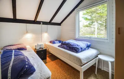 two beds in a room with a window at Two-Bedroom Holiday Home In Thisted in Thisted