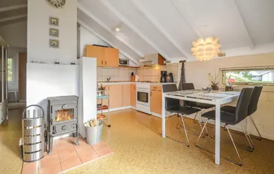 a kitchen with a dining table and a stove at Two-Bedroom Holiday Home In Thisted in Thisted