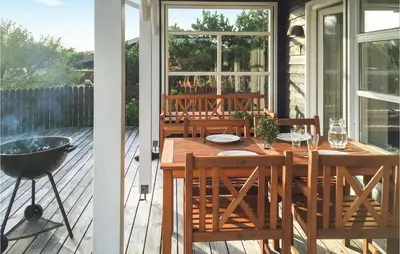 a patio with a wooden table and chairs on a deck at Three-Bedroom Holiday Home In Thisted in Thisted