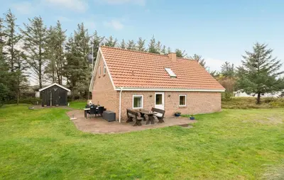 a small brick house with a picnic table in a yard at Four-Bedroom Holiday Home In Thisted in Thisted