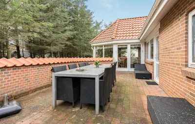 a patio with a table and chairs on a house at Four-Bedroom Holiday Home In Thisted in Thisted
