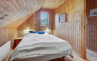 a bedroom with a bed in a wooden wall at Four-Bedroom Holiday Home In Thisted in Thisted