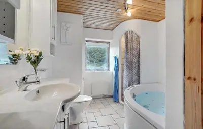a bathroom with a sink and a toilet and a tub at Four-Bedroom Holiday Home In Thisted in Thisted