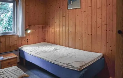a bedroom with a bed in a wooden wall at Holiday Home Klemsvej in Thisted