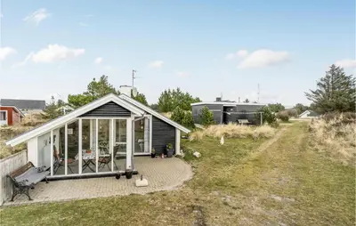 a small house with a greenhouse in a yard at Holiday Home Grårisvej Thisted V in Thisted