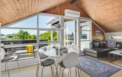a kitchen and living room with a table and chairs at Holiday Home Grårisvej Thisted Vi in Thisted
