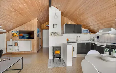 a kitchen with a fireplace in the middle of a room at Holiday Home Grårisvej Thisted Vi in Thisted