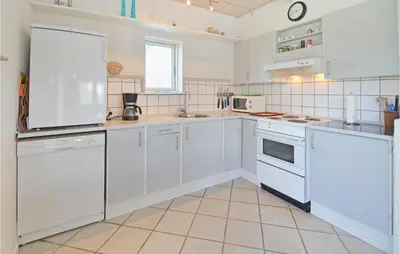 a white kitchen with white cabinets and appliances at Holiday Home Fiskervej Thisted Iii in Thisted