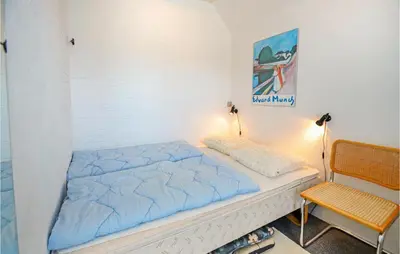 a bed with a blue comforter in a room at Holiday Home Fiskervej Thisted Iii in Thisted