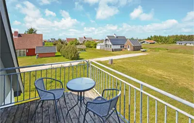 a balcony with chairs and a table and a field at Holiday Home Fiskervej Thisted Iii in Thisted