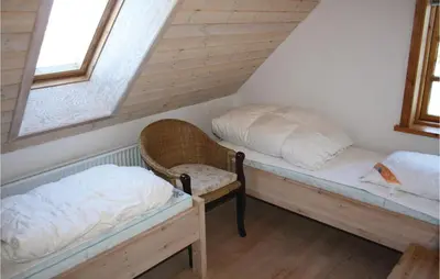 two beds in a room with two windows at Holiday Home Grønkærvej in Thisted