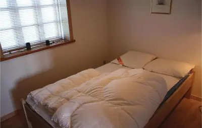 a bed with white sheets and a window in a room at Holiday Home Grønkærvej in Thisted