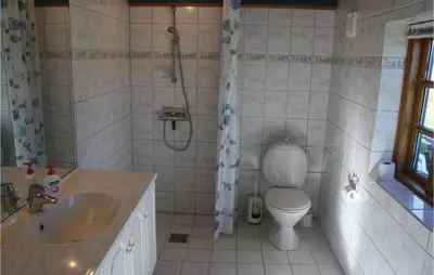 a bathroom with a shower and a toilet and a sink at Holiday Home Grønkærvej in Thisted