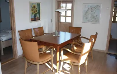 a dining room with a wooden table and chairs at Holiday Home Grønkærvej in Thisted