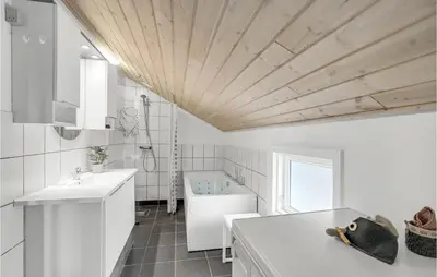 a bathroom with white cabinets and a wooden ceiling at Holiday Home Fiskervej Thisted Iv in Thisted