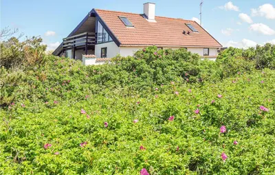 a house on top of a hill with pink flowers at Holiday Home Ørredvej Thisted Ii in Thisted