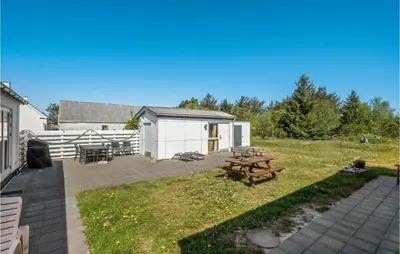 a patio with a picnic table in the yard at Holiday Home Stenbjerg Kirkevej in Snedsted