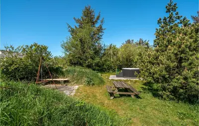a picnic area with a picnic table and a stove at Holiday Home Stenbjerg Kirkevej in Snedsted
