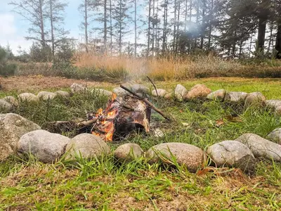 a fire pit in a field with rocks at Charming Cottage near Beach - By Traum Ferienwohnungen in Fjerritslev