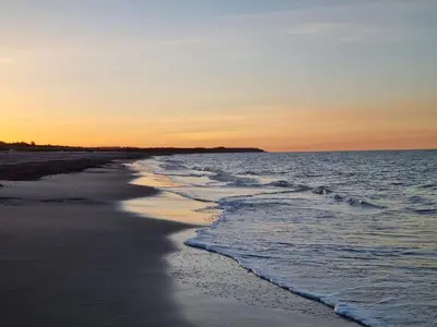 a beach at sunset with the tide coming in at Charming Cottage near Beach - By Traum Ferienwohnungen in Fjerritslev