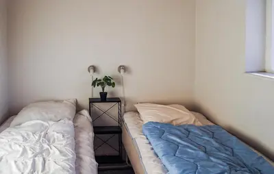 a bedroom with two beds and a night stand with a plant at Holiday Home Gunhildsvej Vestervig Xi in Vestervig