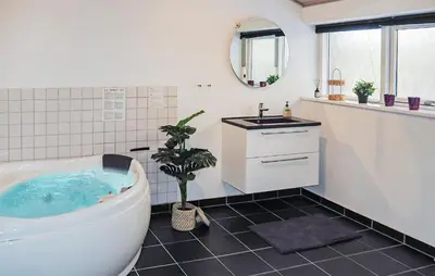 a white bathroom with a tub and a sink at Holiday Home Gunhildsvej Vestervig Xi in Vestervig