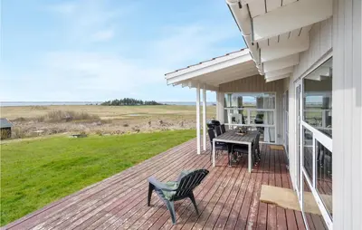 a deck with a table and chairs on a house at Stunning Home In Vestervig With Wifi in Vestervig