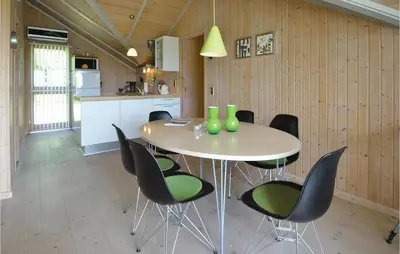 a kitchen and dining room with a table and chairs at Holiday Home Gunhildsvej Vestervig in Vestervig