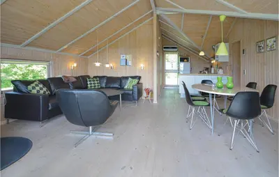 a living room with a couch and a table and chairs at Holiday Home Gunhildsvej Vestervig in Vestervig