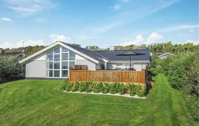 a house with a fence and a yard at Awesome Home In Vestervig With Kitchen in Vestervig