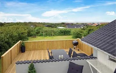 a patio with a table and chairs on a wooden deck at Awesome Home In Vestervig With Kitchen in Vestervig