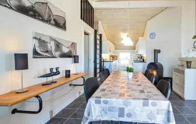 a dining room with a long table and chairs at Awesome Home In Vestervig With Kitchen in Vestervig