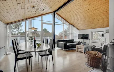 a living room with a table and chairs at Holiday Home Gunhildsvej Vestervig Vi in Vestervig