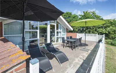 a patio with a table and chairs and an umbrella at Holiday Home Gunhildsvej Vestervig Vi in Vestervig