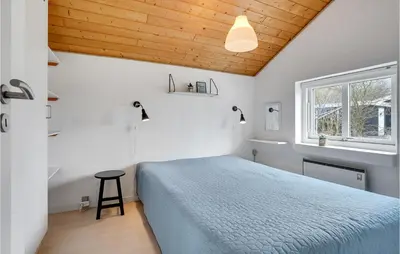 a bedroom with a blue bed and a window at Holiday Home Gunhildsvej Vestervig Vi in Vestervig