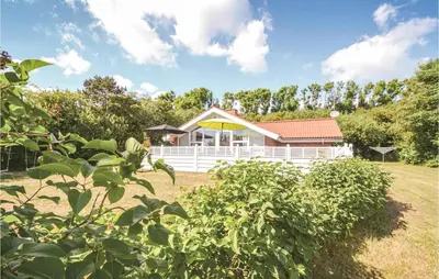 a white house with a yellow umbrella in a yard at Holiday Home Gunhildsvej Vestervig Vi in Vestervig